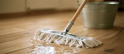 Person wischt geölten Holzboden mit Mopp und Holzbodenseife
